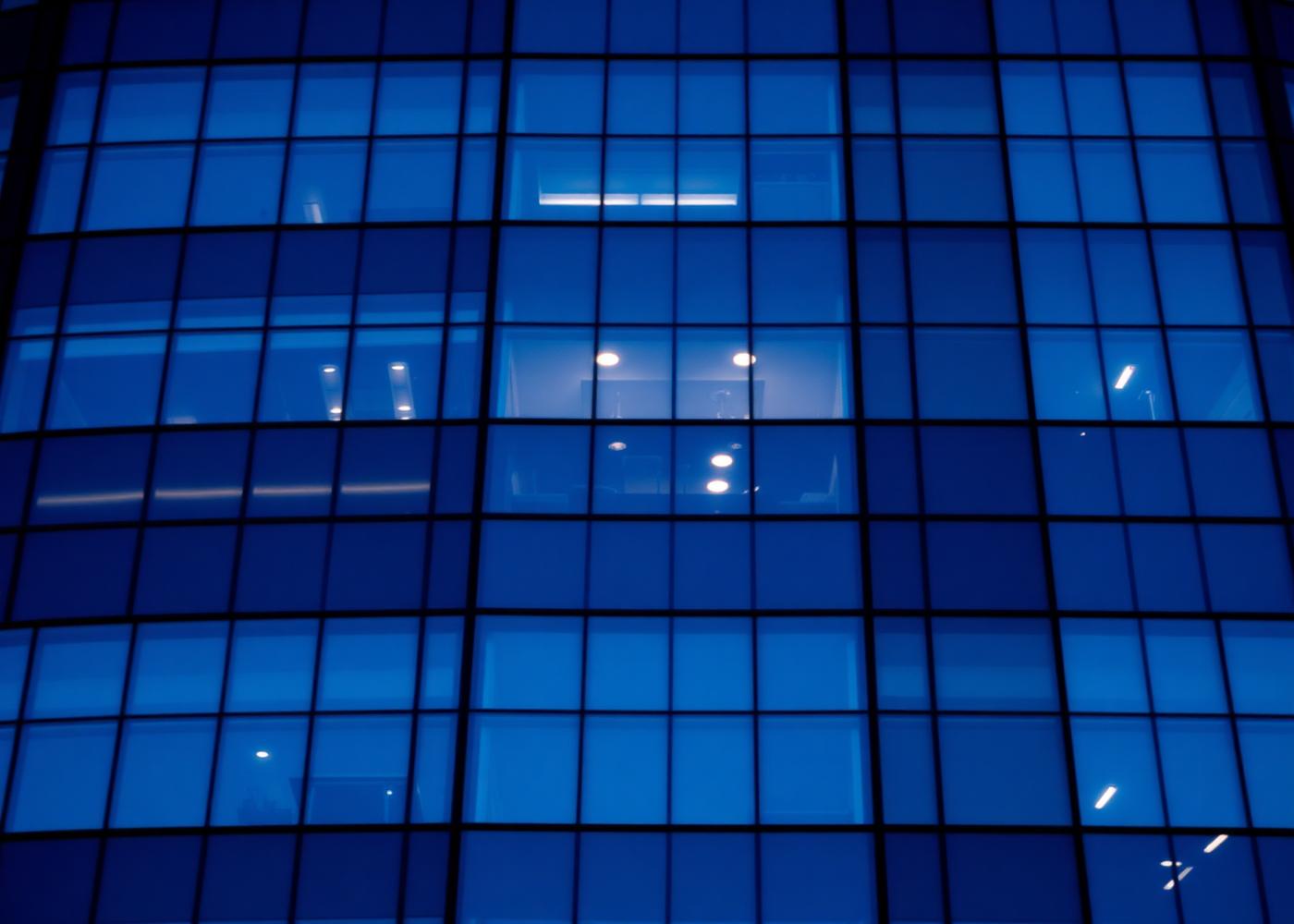 Glass facade of a modern commercial office building at dusk